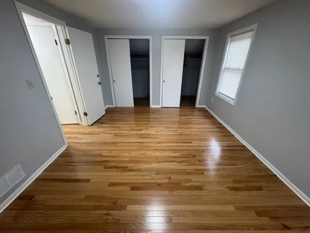 a view of empty room with wooden floor