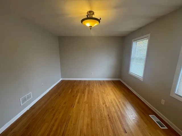 a view of a room with wooden floor and window
