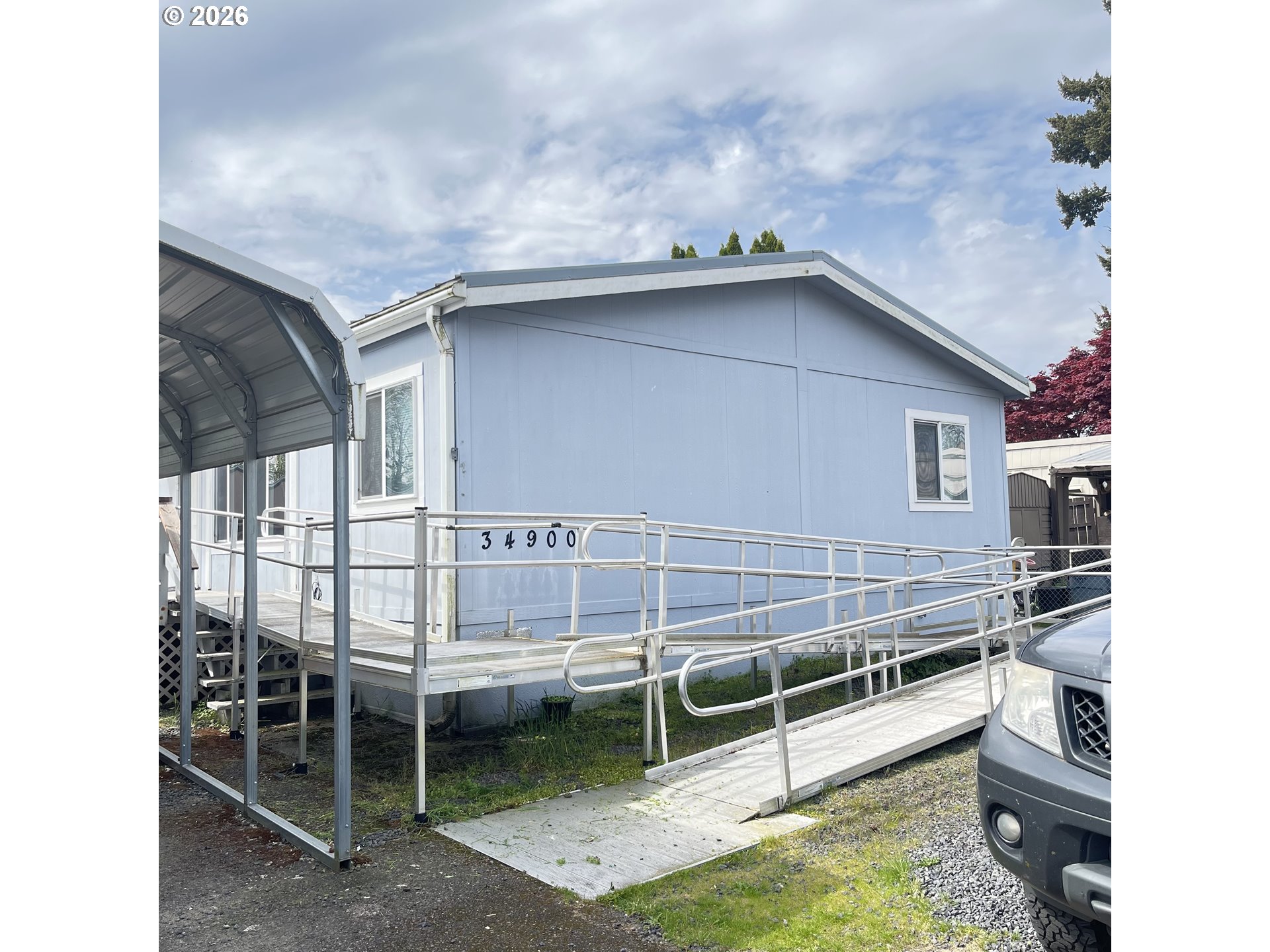 34900 Wendlandt Way, Unit F Scappoose, OR 97056 - Photo 3 of 19 a view of a backyard with a bench and white walls