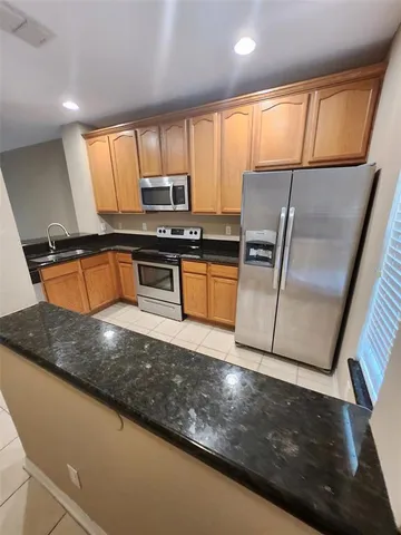 a kitchen with stainless steel appliances granite countertop a sink refrigerator stove and microwave