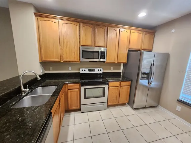 a kitchen with a sink a stove a microwave and refrigerator