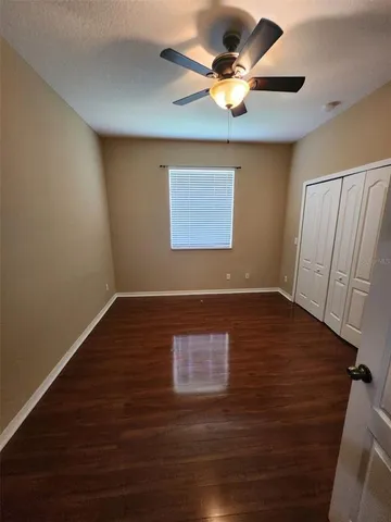 a view of room with hardwood floor and a ceiling fan
