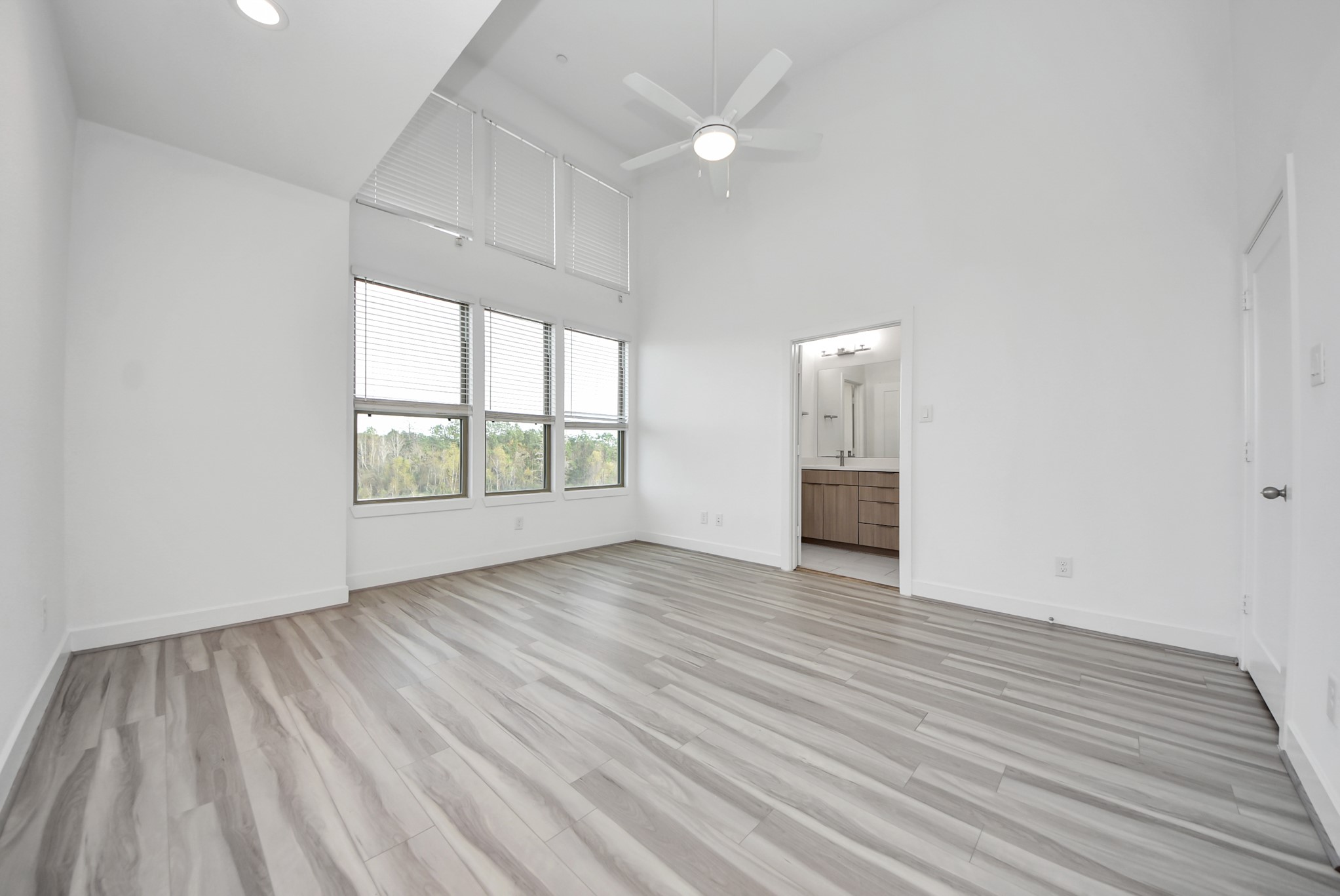 18716 Centro Main Street Conroe, TX 77385 - Photo 34 of 50 Spacious primary bedroom with vaulted ceilings, oversized windows, and a bright, airy layout that creates a comfortable private retreat.