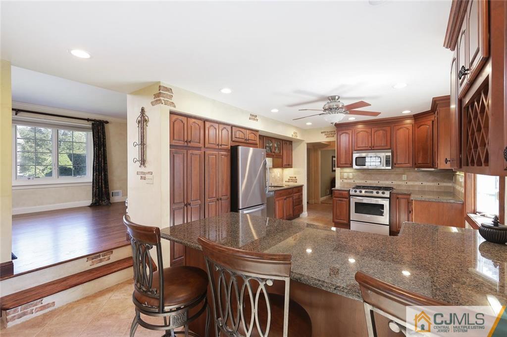 203 Normandy Road Edison, NJ 08820 - Photo 6 of 32 a kitchen with stainless steel appliances granite countertop a stove a refrigerator and a dining table