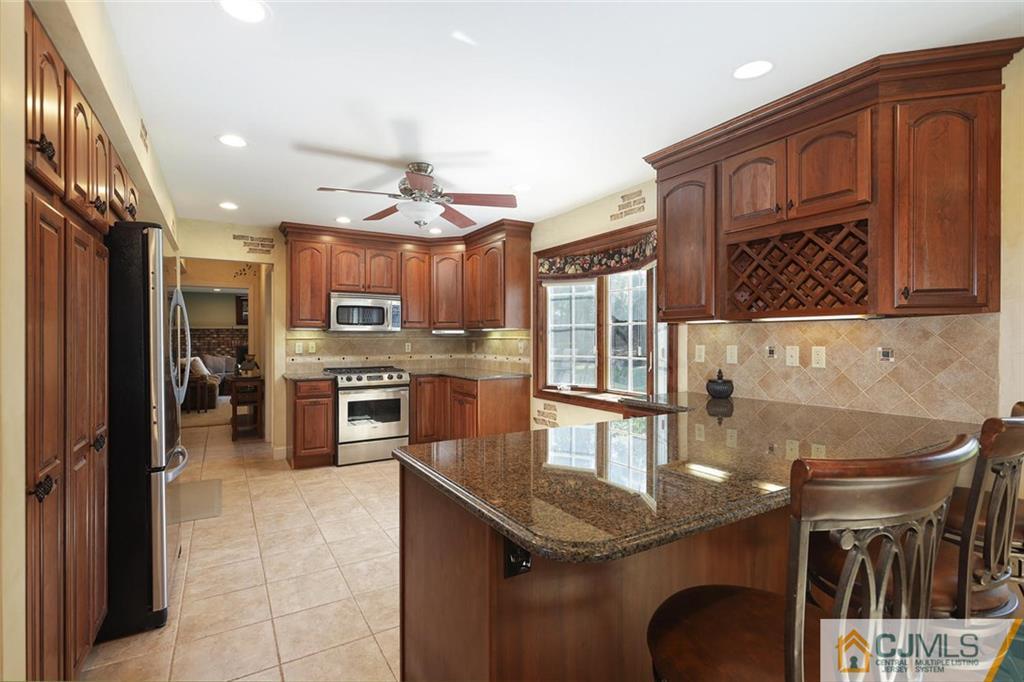 203 Normandy Road Edison, NJ 08820 - Photo 7 of 32 a kitchen with stainless steel appliances granite countertop a sink a stove and cabinets