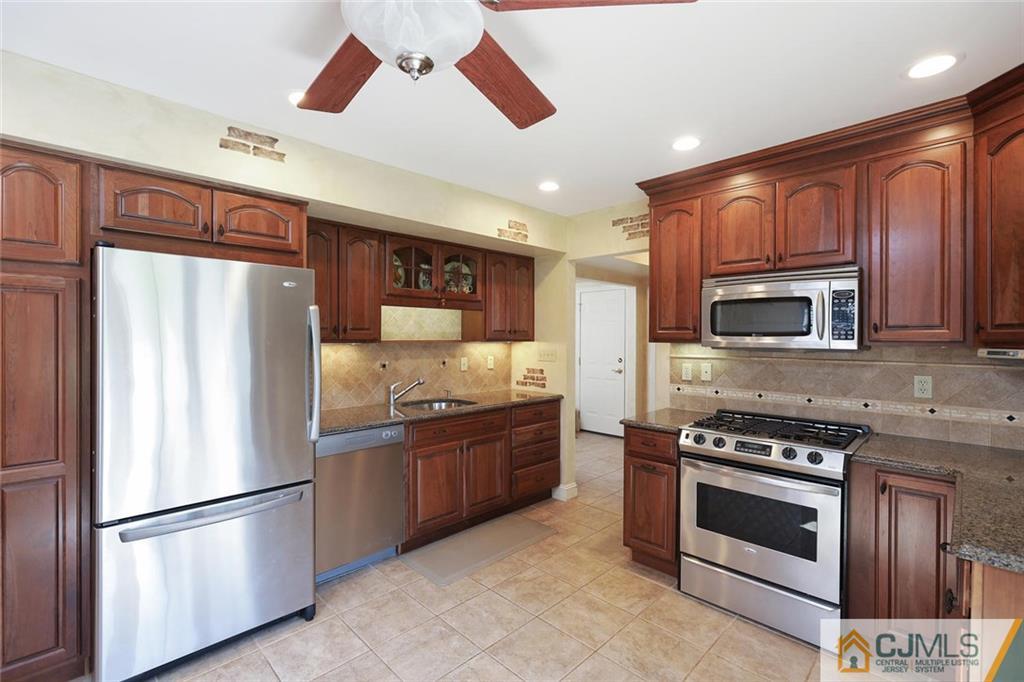 203 Normandy Road Edison, NJ 08820 - Photo 8 of 32 a kitchen with stainless steel appliances granite countertop a refrigerator stove and microwave