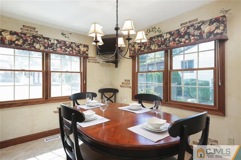 203 Normandy Road Edison, NJ 08820 - Photo 10 of 32 a dining room with wooden floor a chandelier a wooden table and chairs