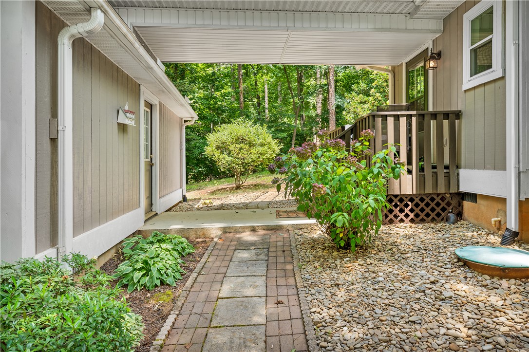 139 Tulip Lane Westminster, SC 29693 - Photo 15 of 37 A quaint pathway leads to a private, wood-sided entry, surrounded by verdant foliage and natural stone landscaping.