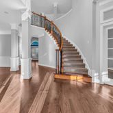 a view of a living room with wooden floor and stairs