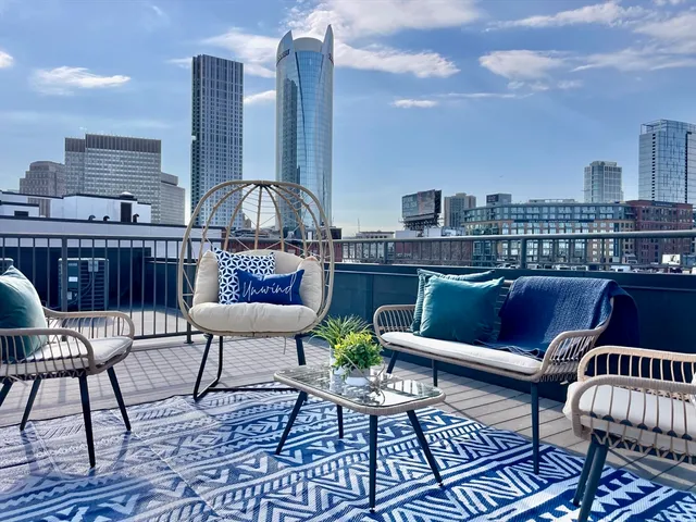 a roof deck with outdoor seating and city view