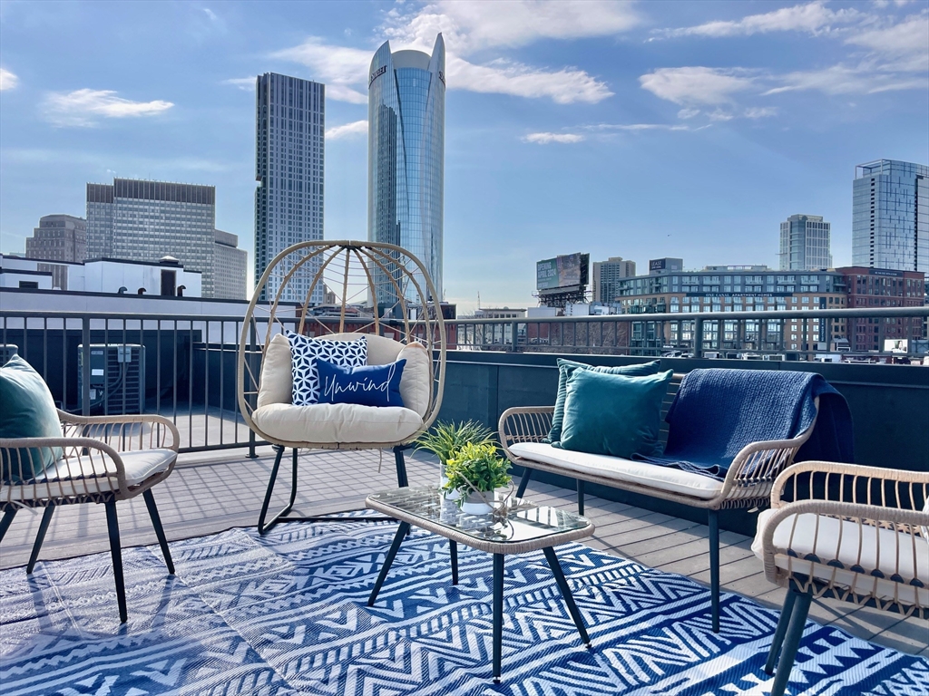 20 Parmenter Street, Unit 403 Boston, MA 02113 - Photo 1 of 16 a roof deck with outdoor seating and city view