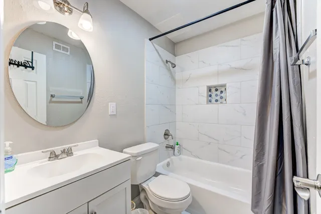 a view of front door with chair and potted plants