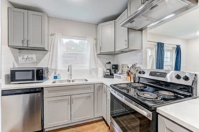 a kitchen with stainless steel appliances a sink a stove and cabinets