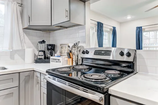 a kitchen with a stove and white cabinets
