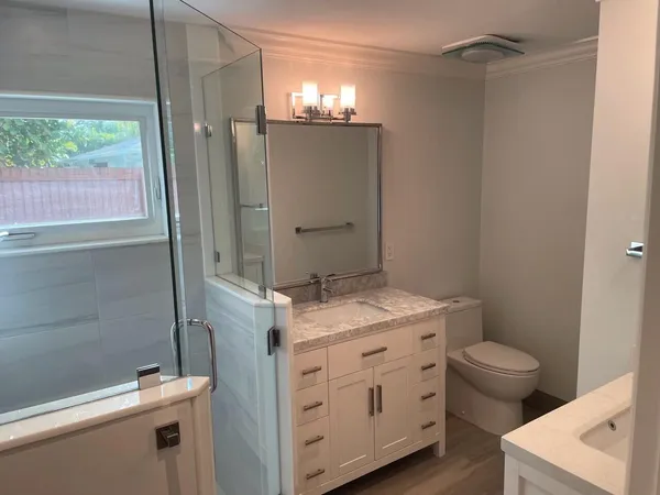 a bathroom with a granite countertop sink toilet and shower