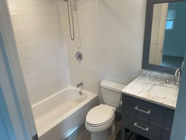 a bathroom with a granite countertop sink toilet and shower