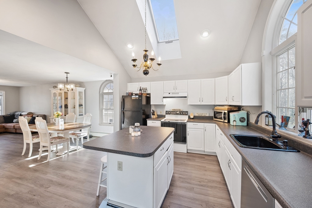 164 Turkey Hill Road Rutland, MA 01543 - Photo 3 of 30 a kitchen with cabinets a sink dishwasher a stove and a dining table with wooden floor