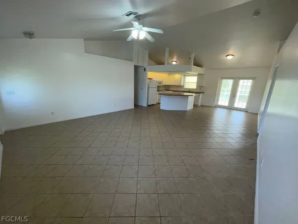 an empty room with cabinet and windows