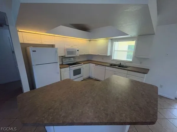 a kitchen with kitchen island a sink a counter top space and appliances