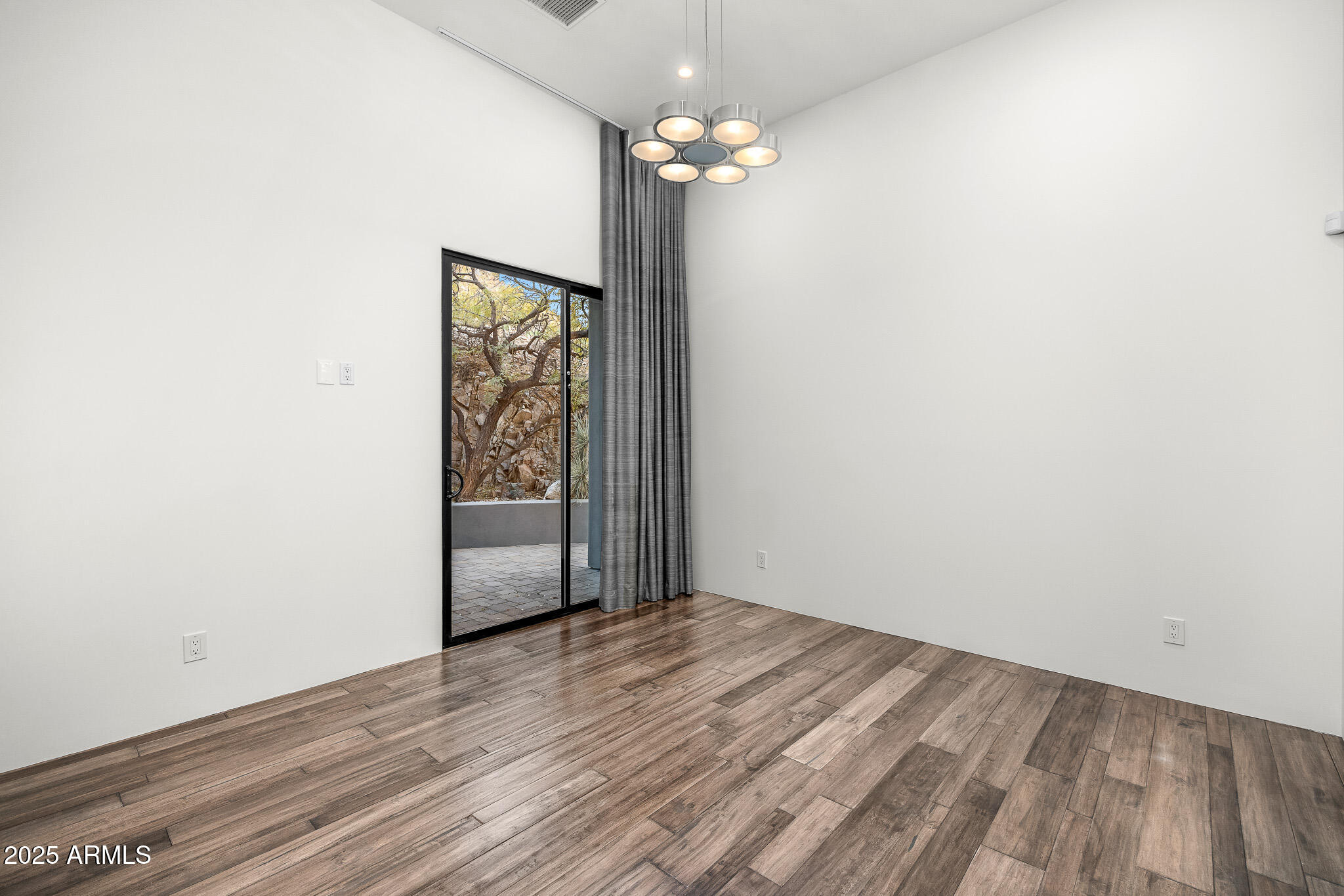 4129 East Sandy Mountain Road Paradise Valley, AZ 85253 - Photo 48 of 76 an empty room with wooden floor chandelier fan and closet area