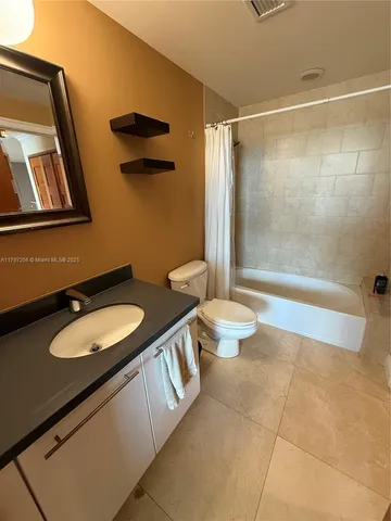 a bathroom with a granite countertop sink mirror vanity and toilet