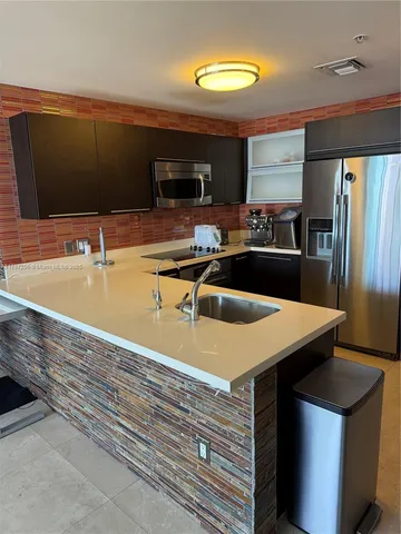 a kitchen with stainless steel appliances granite countertop a sink a stove and a microwave