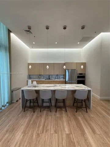 a table and chairs in a room with wooden floor