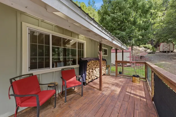 a view of a house with a yard and large tree