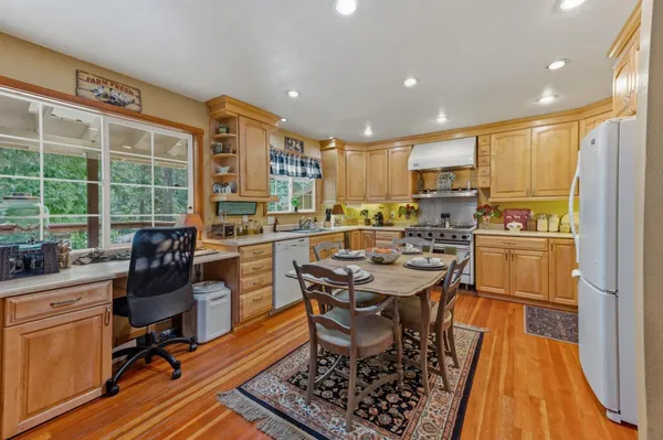 a kitchen with a table chairs stove and refrigerator