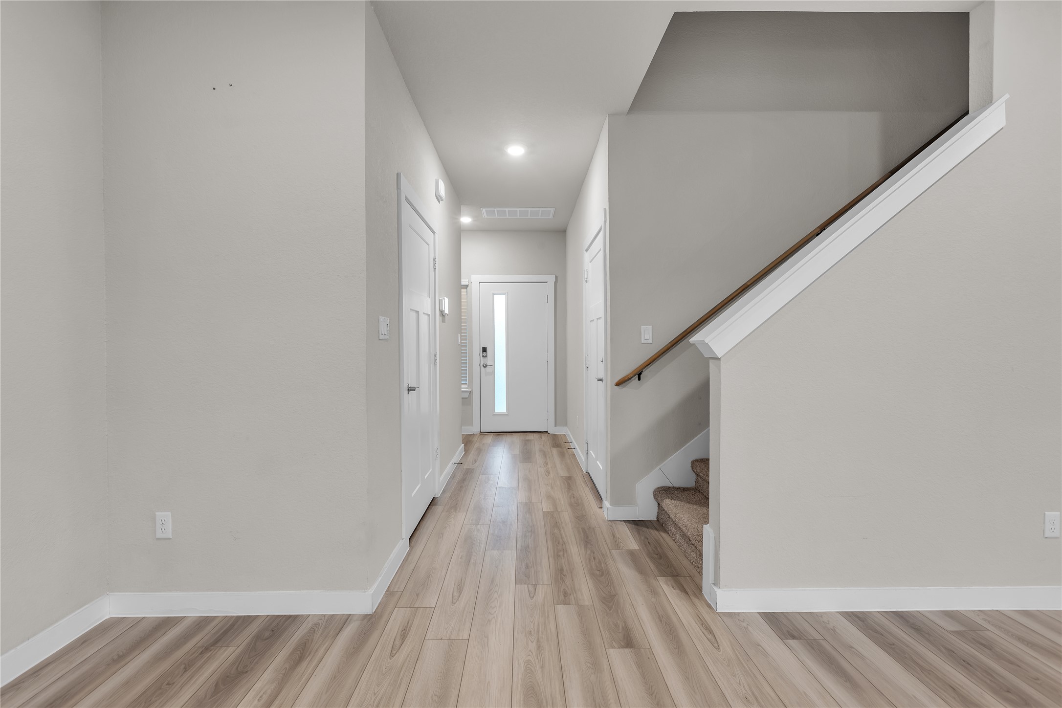 1212 Tipton Street Georgetown, TX 78633 - Photo 2 of 20 A welcoming entry hall featuring modern plank flooring and a sleek staircase.