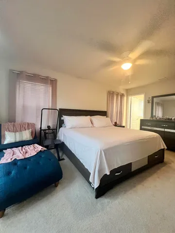 a bedroom with a bed chair and window