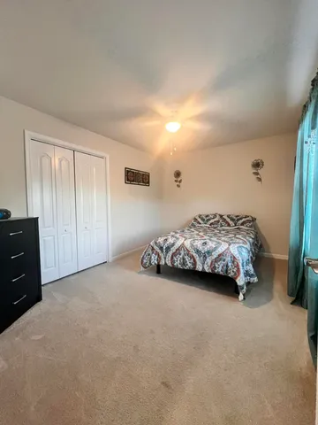 a spacious bedroom with a bed and a cabinets