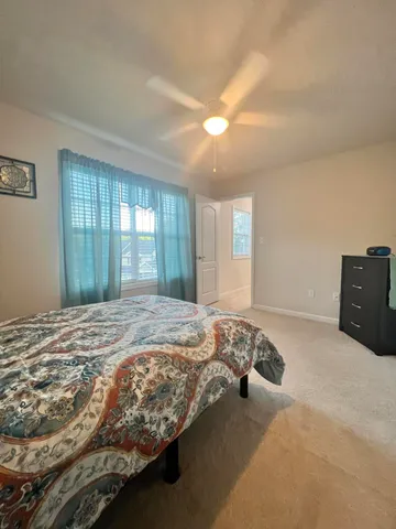 a bed sitting in a spacious bedroom next to a window