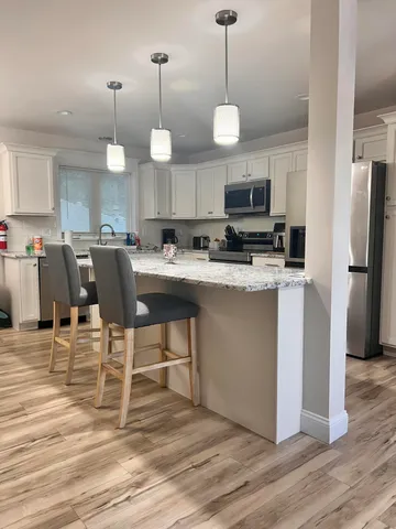 a view of a dining room and kitchen with a table chairs and refrigerator