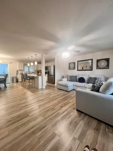 a living room with furniture and a dining table with kitchen view