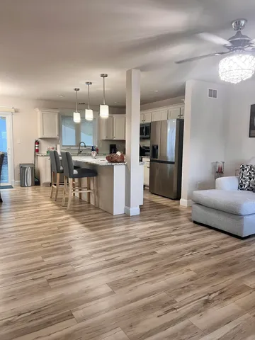 a view of a kitchen with kitchen island dining room and wooden floor