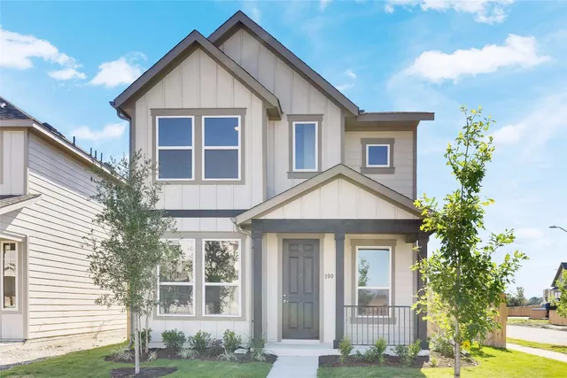 a view of a white house next to a yard