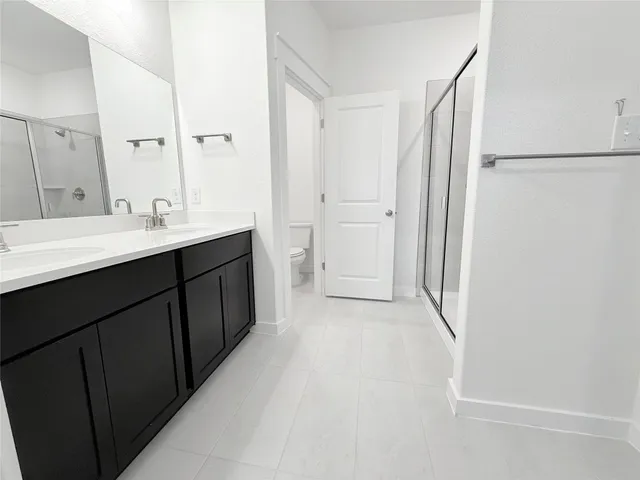 a bathroom with a double vanity sink a mirror and a shower