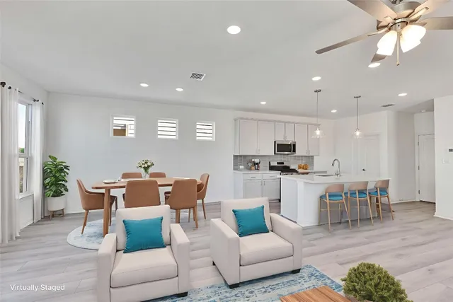 a view of kitchen with stainless steel appliances wooden floor and large window