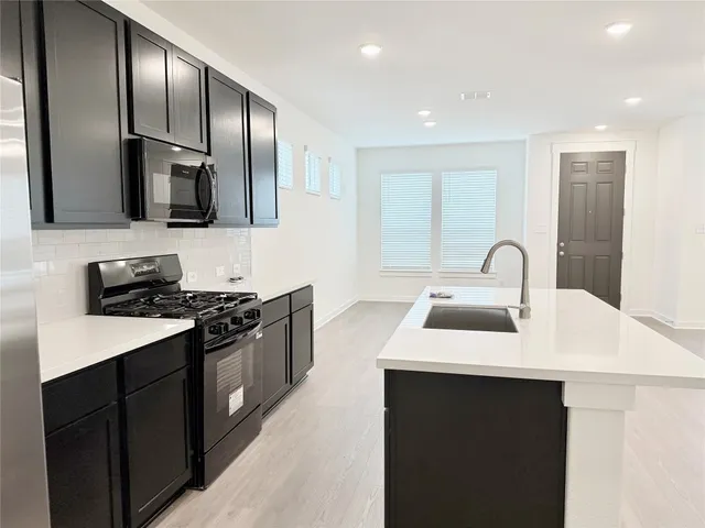 a kitchen with stainless steel appliances a sink stove and refrigerator