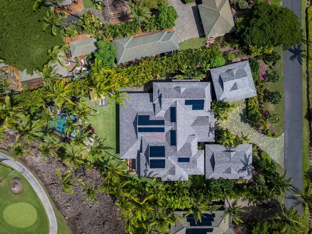 an aerial view of a house with garden space and street view