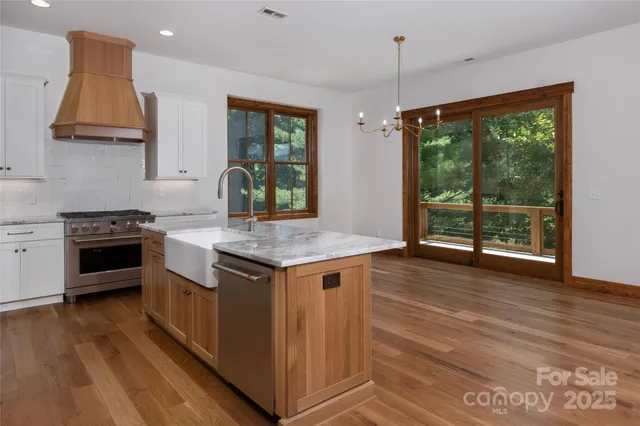 a kitchen with granite countertop a stove and a wooden floors