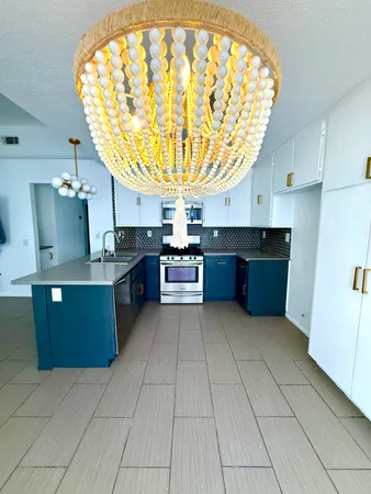 a large kitchen with stainless steel appliances granite countertop a stove and large cabinets