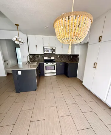 a kitchen with stainless steel appliances a sink a stove a microwave and cabinets