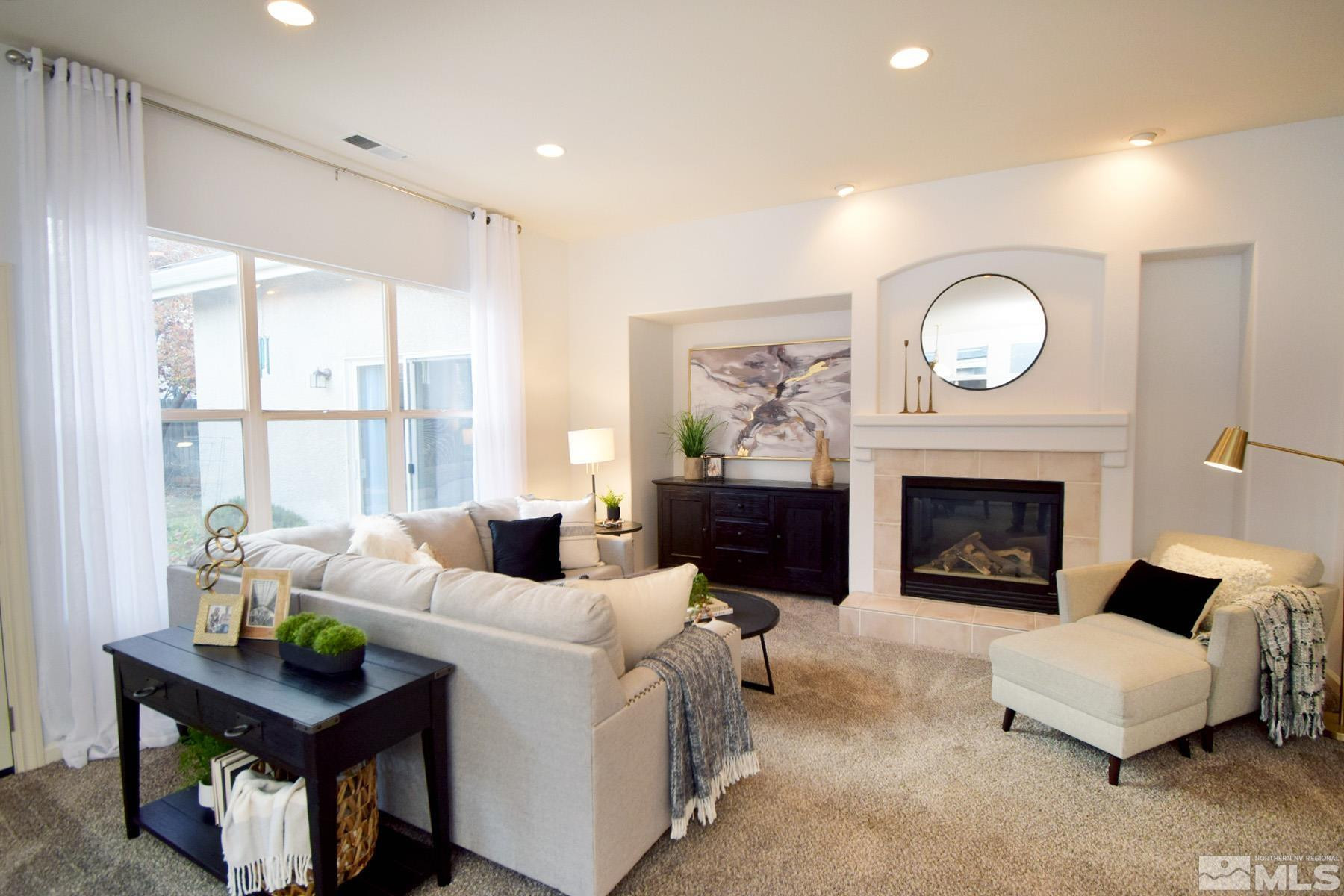 9673 Shadowstone Way Reno, NV 89521 - Photo 8 of 31 a living room with furniture a fireplace and a large window
