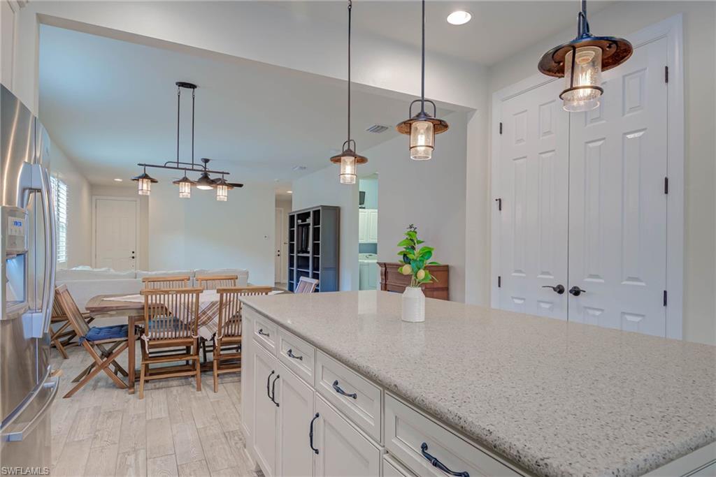 5761 Mayflower Way Ave Maria, FL 34142 - Photo 12 of 39 a spacious kitchen with a table chairs and chandelier