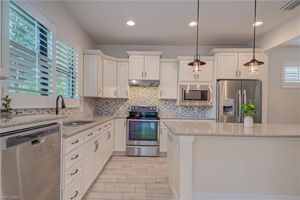 5761 Mayflower Way Ave Maria, FL 34142 - Photo 13 of 39 a kitchen with stainless steel appliances granite countertop a stove a sink and a refrigerator