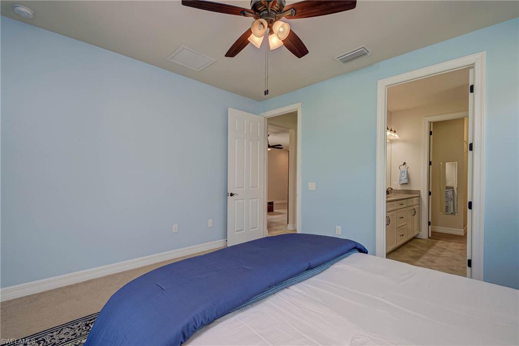 5761 Mayflower Way Ave Maria, FL 34142 - Photo 16 of 39 a bedroom with a bed and a chandelier