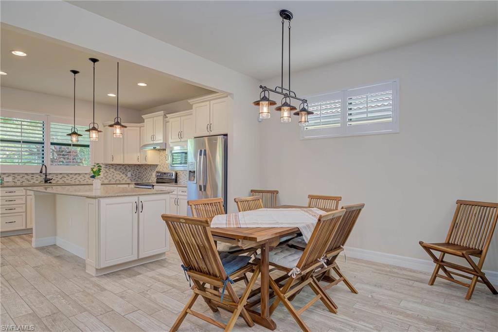 5761 Mayflower Way Ave Maria, FL 34142 - Photo 7 of 39 a kitchen with a dining table chairs stainless steel appliances and cabinets