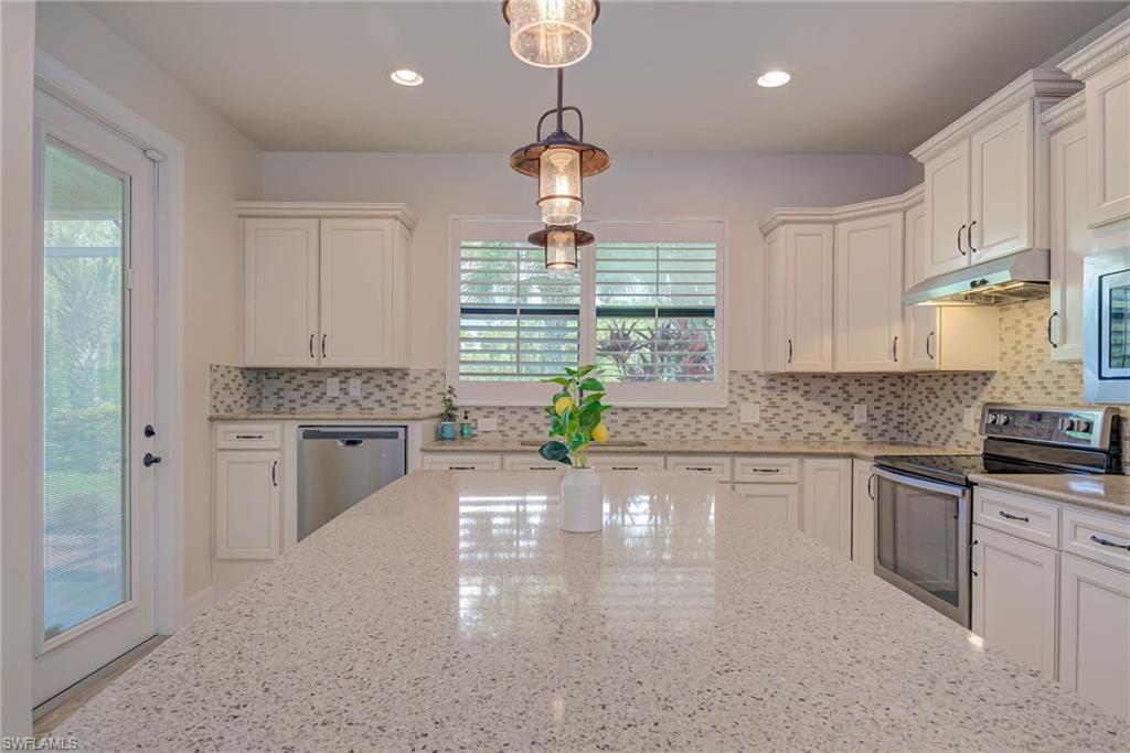 5761 Mayflower Way Ave Maria, FL 34142 - Photo 8 of 39 a kitchen with granite countertop a stove a sink a window and stainless steel appliances
